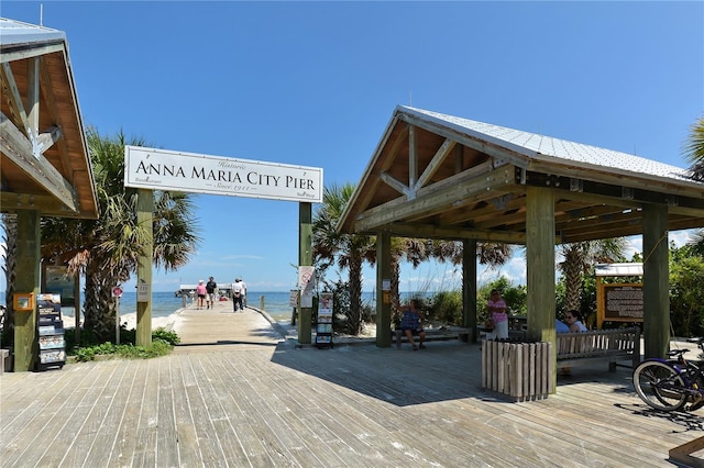 view of property's community with a beach view, a deck with water view, and a gazebo