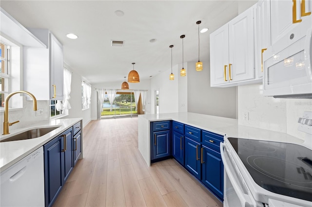 kitchen featuring decorative light fixtures, sink, white cabinets, blue cabinetry, and white appliances