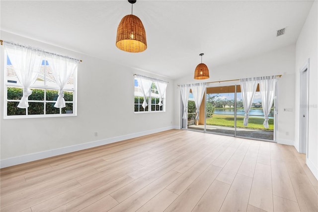 spare room featuring lofted ceiling and light wood-type flooring