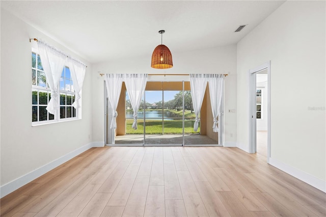 empty room featuring vaulted ceiling and light hardwood / wood-style floors