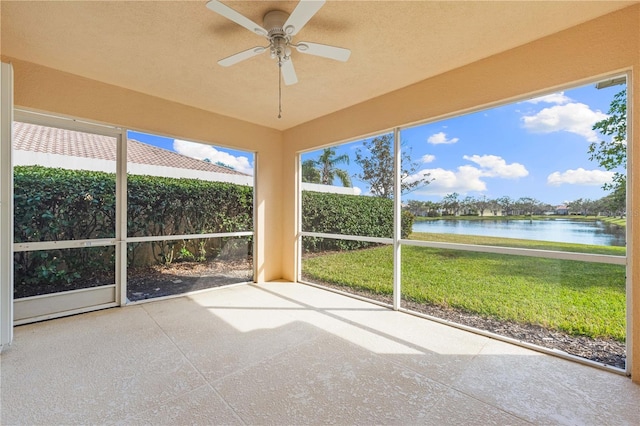 unfurnished sunroom with a water view and ceiling fan