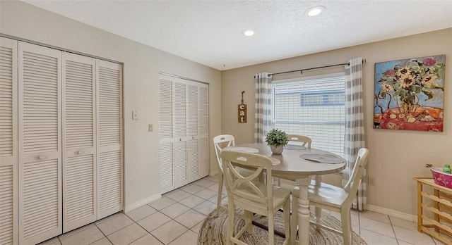 dining room featuring light tile patterned flooring and a textured ceiling