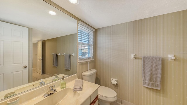 bathroom featuring tile patterned floors, vanity, toilet, and a textured ceiling