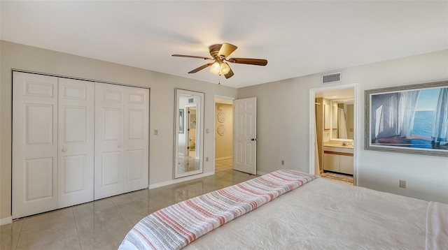 tiled bedroom with ceiling fan, ensuite bath, and a closet