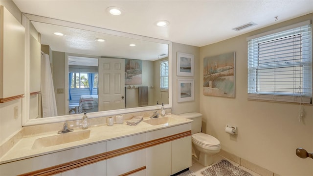 bathroom with vanity, tile patterned floors, and toilet