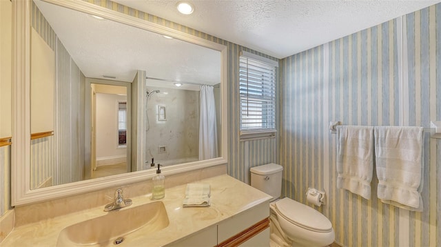 bathroom featuring vanity, a shower with curtain, toilet, and a textured ceiling