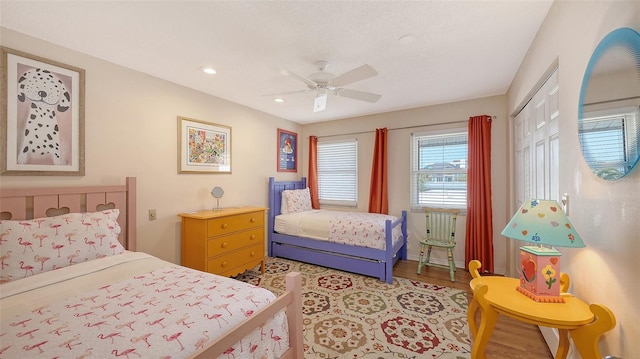 bedroom with ceiling fan, light hardwood / wood-style floors, and a closet