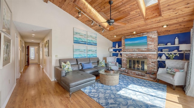 living room featuring wood ceiling, track lighting, and light hardwood / wood-style floors