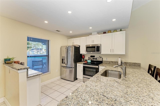 kitchen with white cabinetry, appliances with stainless steel finishes, sink, and kitchen peninsula