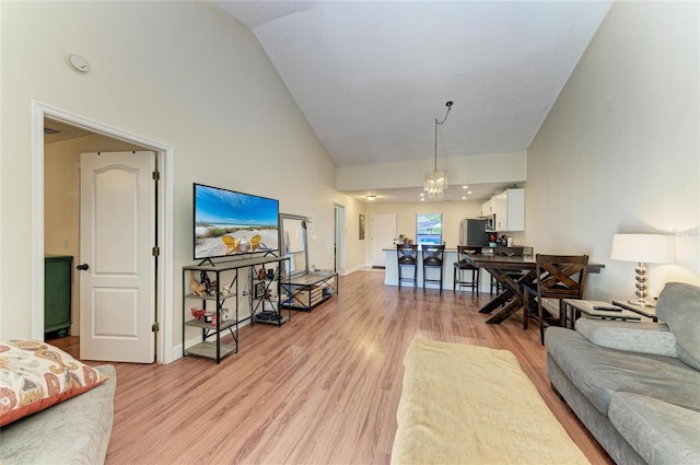 living room with high vaulted ceiling and light hardwood / wood-style floors