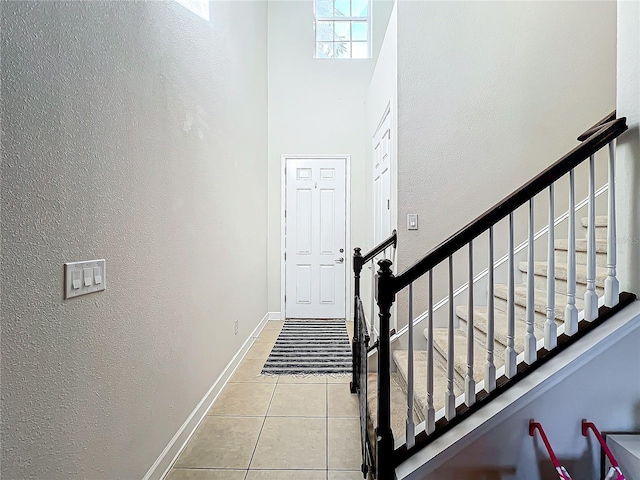 foyer entrance featuring a high ceiling and light tile patterned flooring