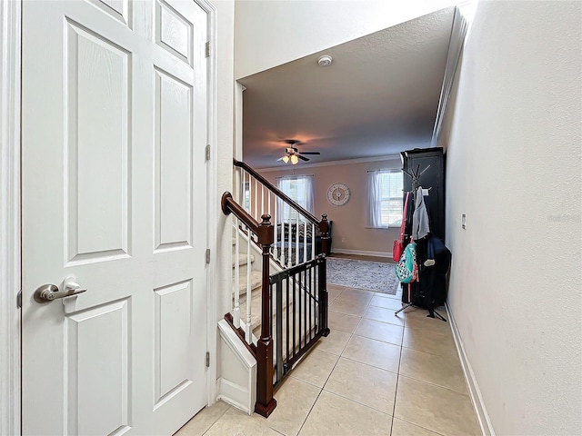 staircase with ornamental molding, tile patterned floors, and ceiling fan