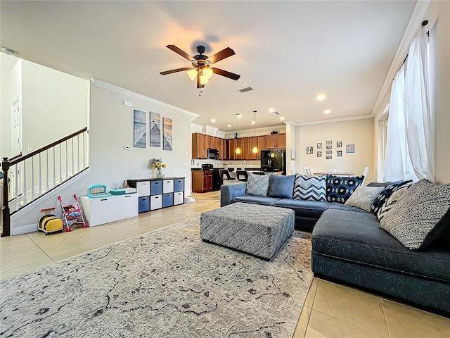 living room featuring light tile patterned floors, ornamental molding, and ceiling fan