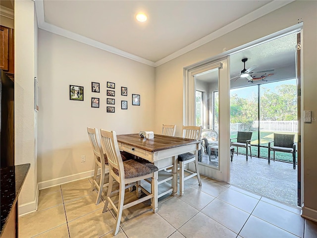 dining area featuring ceiling fan, ornamental molding, and light tile patterned floors