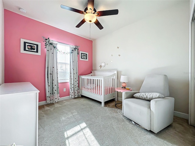 carpeted bedroom with a nursery area and ceiling fan