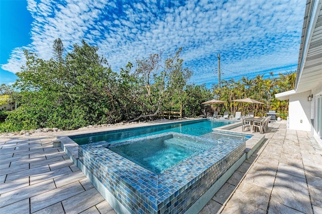 view of swimming pool with a patio and an in ground hot tub