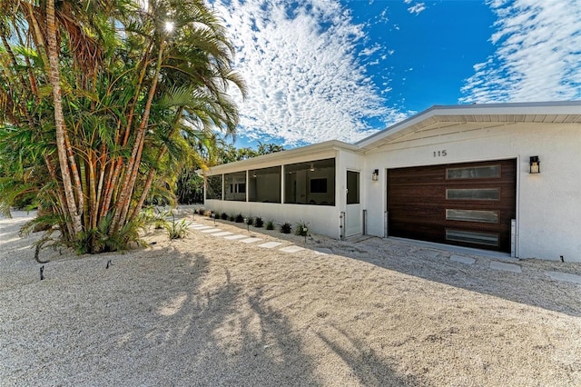 view of front facade with a garage and a sunroom