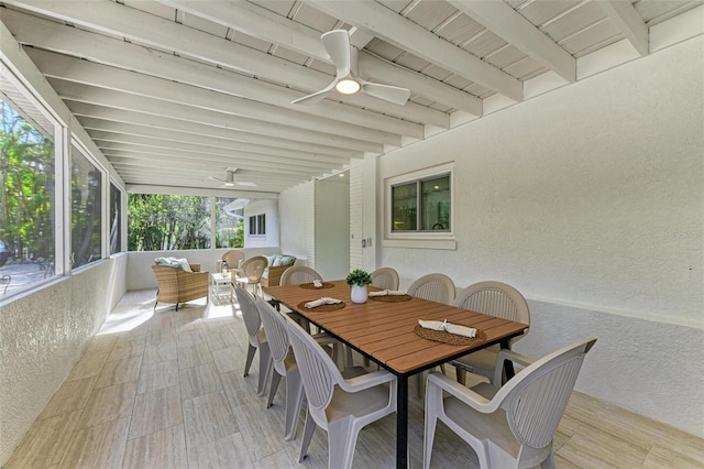 sunroom featuring beamed ceiling and ceiling fan