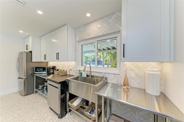 kitchen featuring tasteful backsplash, stainless steel appliances, and white cabinets