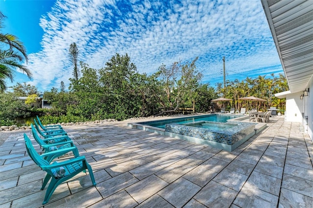 view of swimming pool featuring an in ground hot tub and a patio area