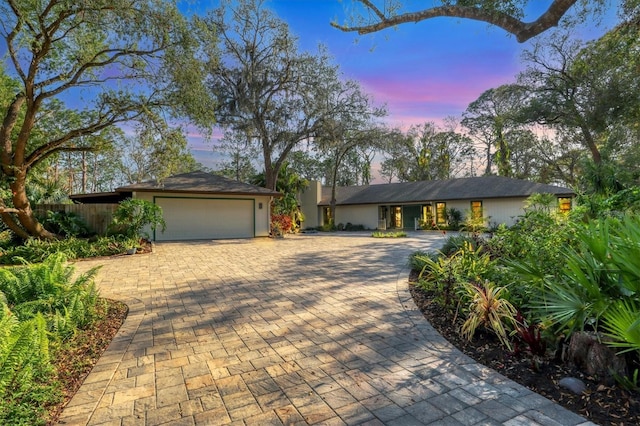 ranch-style house with an attached garage and decorative driveway