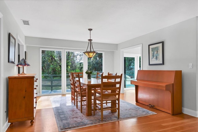 dining space featuring baseboards, visible vents, and wood finished floors