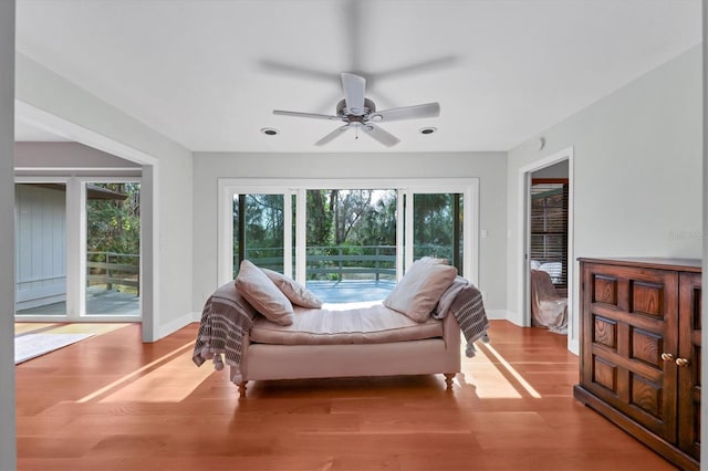 bedroom featuring baseboards, multiple windows, wood finished floors, and access to exterior