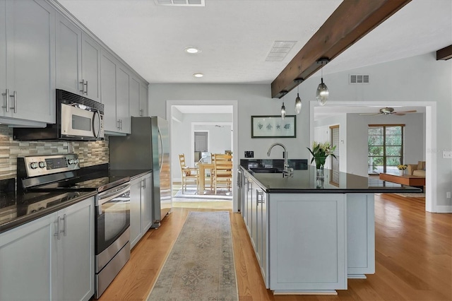 kitchen featuring stainless steel appliances, sink, gray cabinetry, and decorative light fixtures