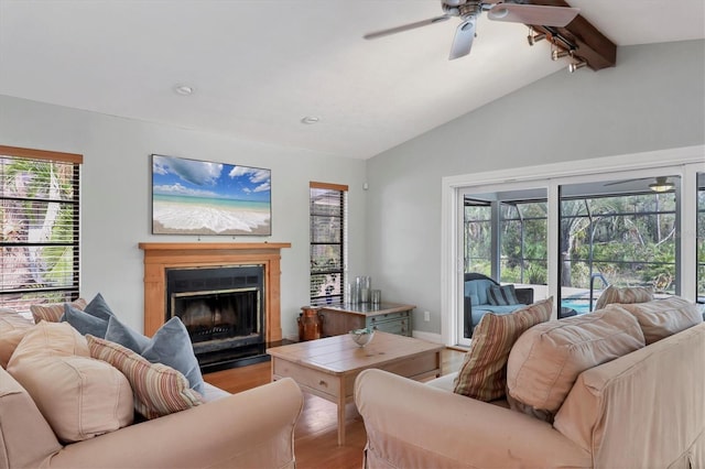 living room with a fireplace, lofted ceiling with beams, a ceiling fan, wood finished floors, and baseboards