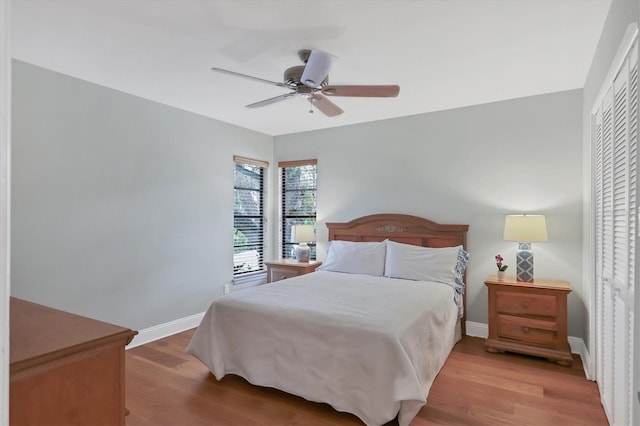 bedroom with ceiling fan, a closet, and light hardwood / wood-style flooring