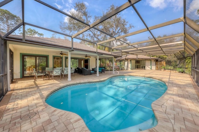 view of pool with a patio area, ceiling fan, and glass enclosure