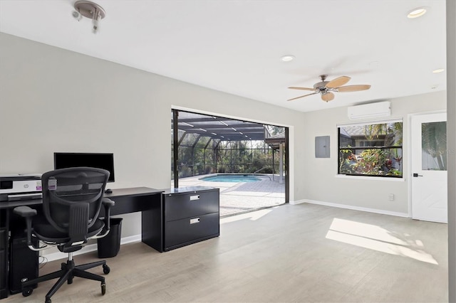 office featuring ceiling fan, a wall unit AC, electric panel, and light wood-type flooring