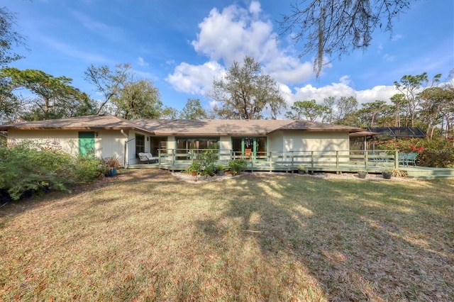 rear view of house featuring a lanai and a yard