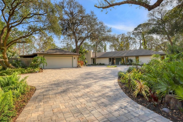 ranch-style house with a garage and decorative driveway