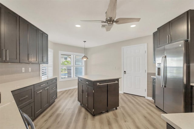 kitchen with pendant lighting, stainless steel fridge, dark brown cabinetry, and light wood-type flooring