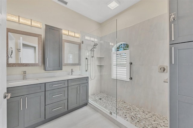 bathroom featuring tiled shower and vanity