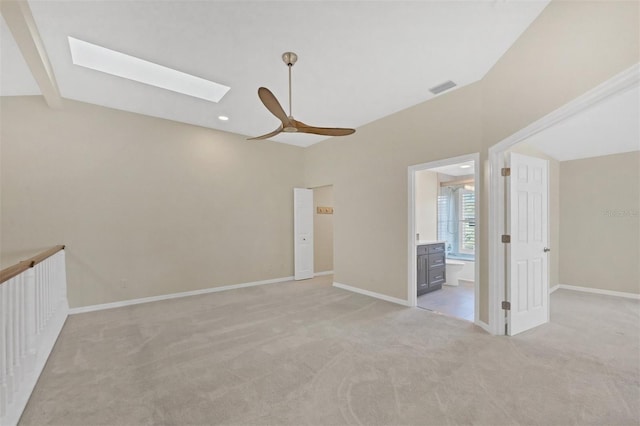 unfurnished room featuring ceiling fan, a skylight, and light carpet