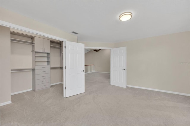 unfurnished bedroom with light carpet and a closet