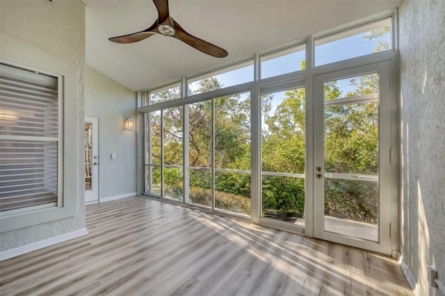 unfurnished sunroom with ceiling fan, lofted ceiling, and a wealth of natural light