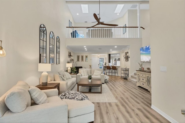 1719 Starling Dr Unit 1719, Sarasota, FL 34231 - living area with a skylight, a high ceiling, a ceiling fan, and light wood-style flooring