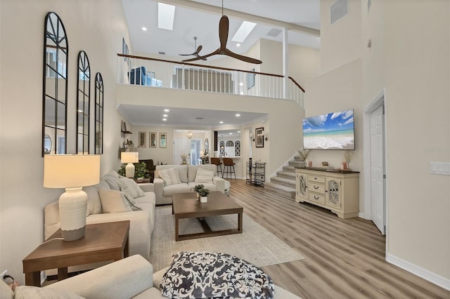 1719 Starling Dr Unit 1719, Sarasota, FL 34231 - living area featuring a ceiling fan, a high ceiling, wood finished floors, stairway, and a skylight