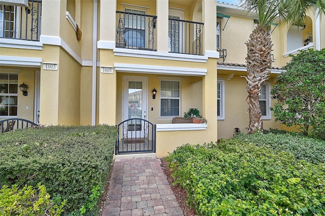 doorway to property featuring a gate and stucco siding