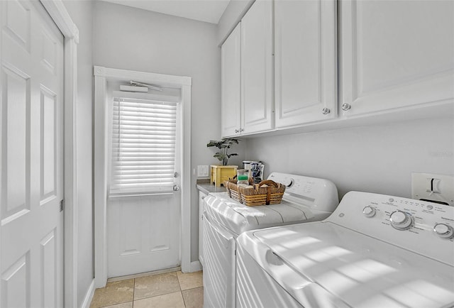 laundry room featuring light tile patterned floors, cabinet space, and separate washer and dryer