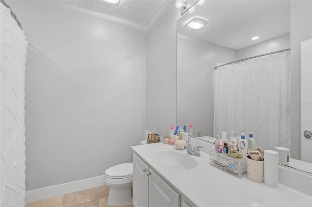 bathroom featuring tile patterned floors, toilet, a textured ceiling, baseboards, and vanity