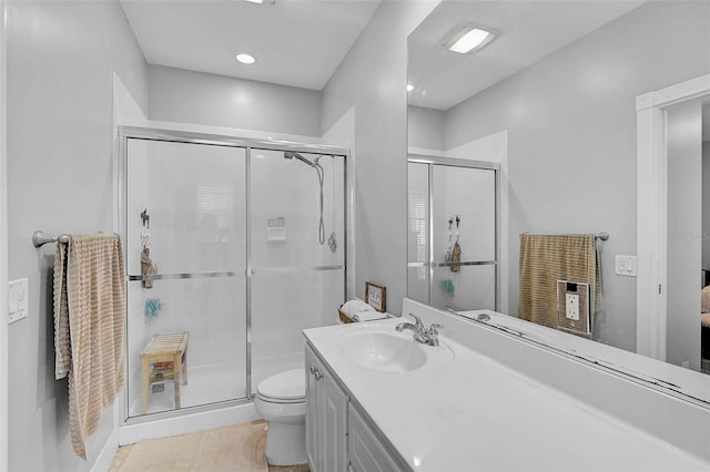 bathroom featuring vanity, a shower stall, toilet, and tile patterned floors