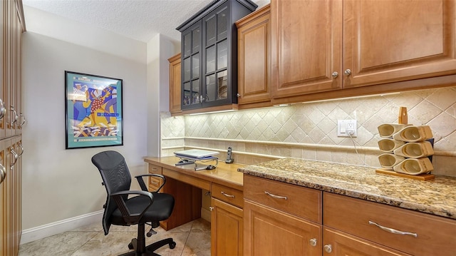 office area featuring baseboards, a textured ceiling, and light tile patterned flooring