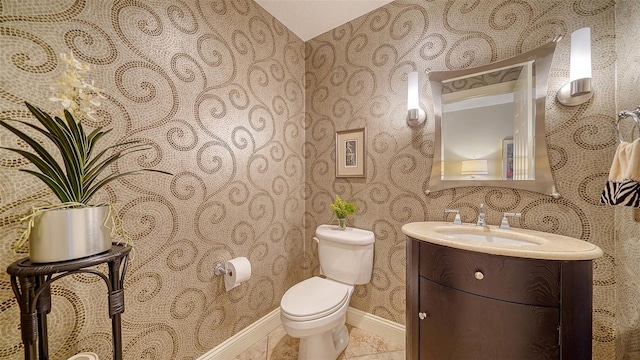 half bath featuring wallpapered walls, baseboards, toilet, tile patterned flooring, and vanity