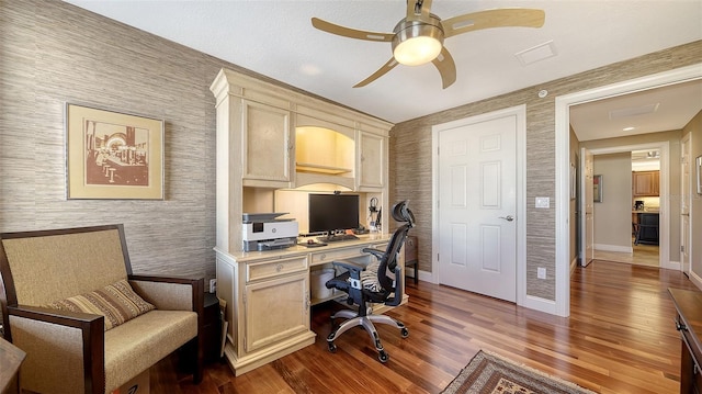 home office featuring baseboards, ceiling fan, wood finished floors, and wallpapered walls