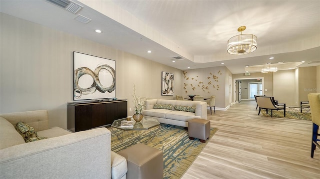 living room with a notable chandelier, recessed lighting, visible vents, baseboards, and light wood finished floors