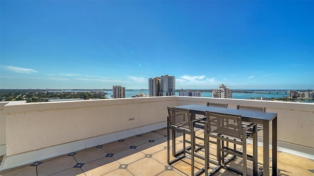 balcony featuring a water view and a city view